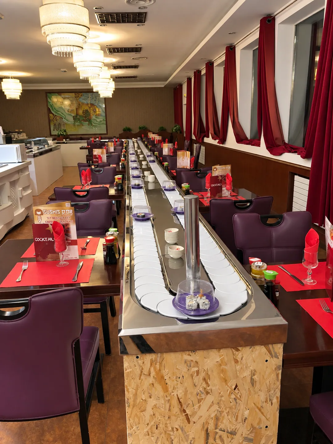 The Sushi d'or dining room: the sushi conveyor belt runs through the room between tables with red place mats.